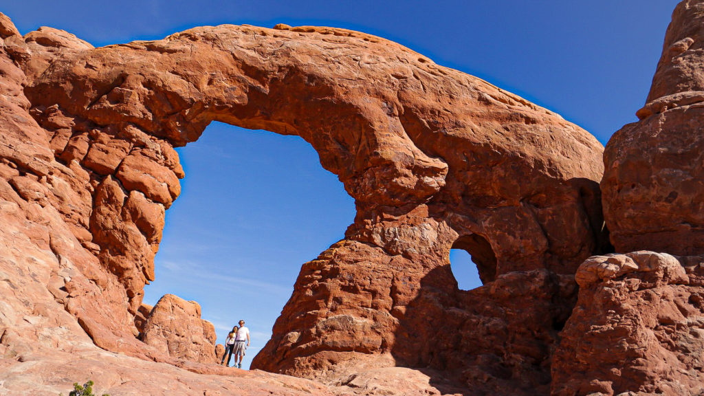 Briana and Billy in front of turret arch in arches national park